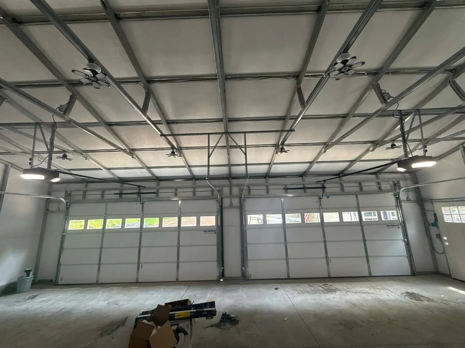 Interior view of three installed garage doors and track hardware