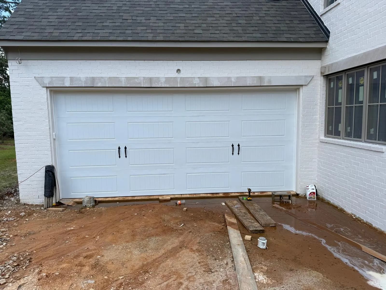White carriage-style garage door with decorative black handles